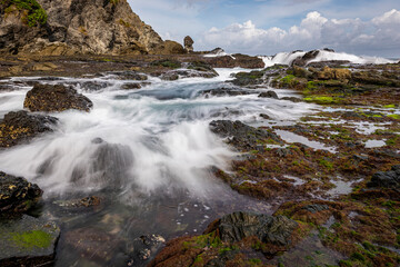 Sea water flowing view in Siung volcanic rock beach, Java Island, Indonesia