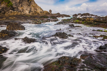 Sea water flowing view in Siung volcanic rock beach, Java Island, Indonesia