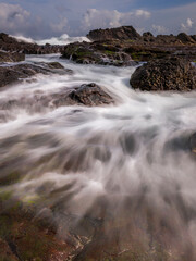 Sea water flowing view in Siung volcanic rock beach, Java Island, Indonesia