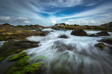 Beautiful sea wave flowing view into rock beach channel