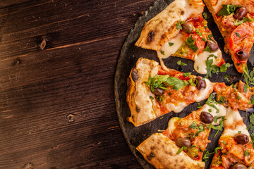 Pizza gourmet tagliata a spicchi con totanetti freschi, olive, prezzemolo e mozzarella