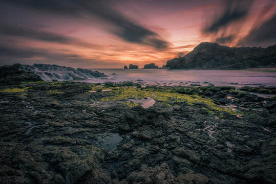 Siung beach silhouette landscape view in long exposure shot with motion blur cloud background