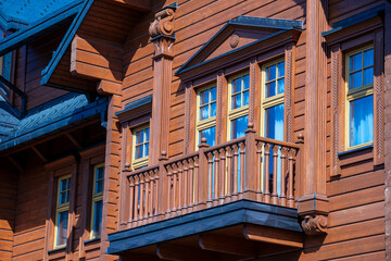 Fototapeta na wymiar Ukrainian traditional rural wooden house, background exterior facade with windows frame and balcony. Kyiv, Ukraine