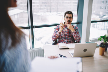 Amazed Caucasian professional employer classic eyewear impressed with received information during...