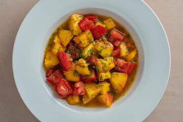 Colorful summer salad with tomato and peach, close up. Top view.