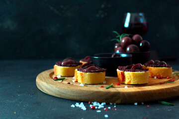 Canape or crostini with pate of olives on dark background. Top view with copy space. Healthy snack. - obrazy, fototapety, plakaty