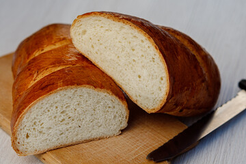 Delicious freshly baked bread and a knife on the kitchen board