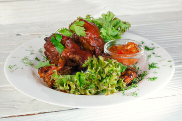 Grilled fried meat on a plate with salad and herbs, shish kebab in tomato sauce
