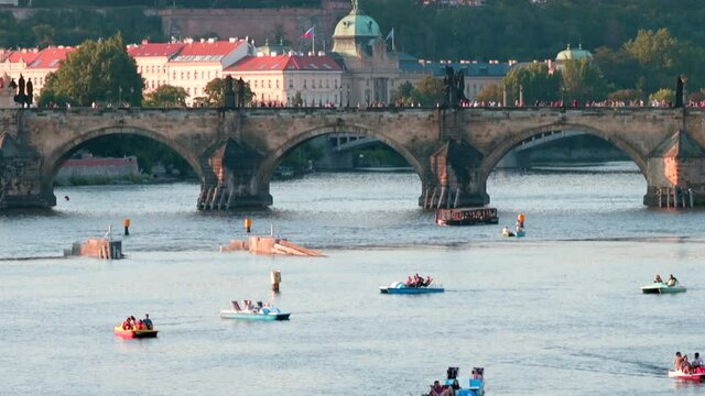Many catamarans on the river on a sunny day. People spend their leisure time in the open. A pleasant atmosphere of the joy of life. Urban river tourism.