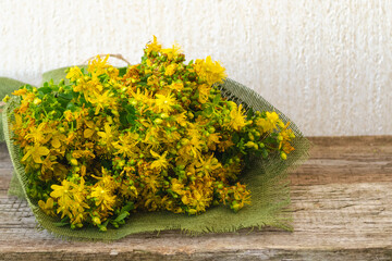 A bouquet of flowers St. John's wort lies on old boards