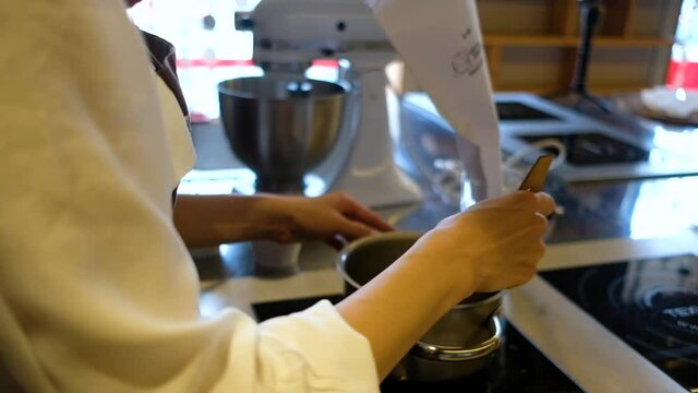 Woman hands whipping with mixer. Making dessert in modern kitchen