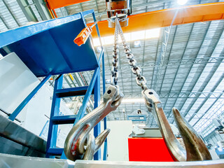 Overhead crane and machine inside factory building, industrial background.