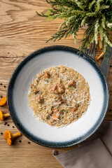 Classic italian risotto with forest mushrooms , top view on wooden background, herbs and mushrooms around