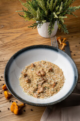 Top view of creamy mushroom risotto in a restaurant, with white wine added, food styling with ingredients around