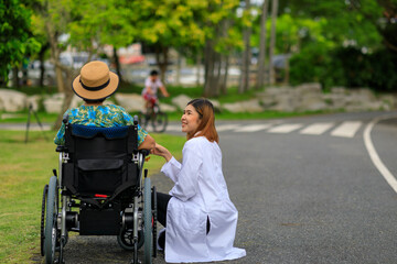 Asian female doctor teach a senior patient how to use the electric wheelchair.