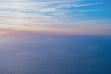 Fototapeta na wymiar 飛行機の窓から海を見下ろす