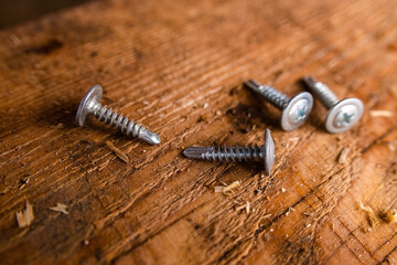Bolts lie on a wooden Board on a construction site