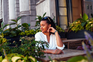 young pretty african girl posing cheerful in cafe outdoor, lifestyle people concept