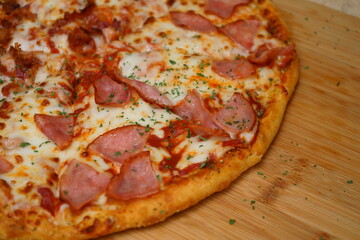 Pizza de jamón y queso en tabla de madera