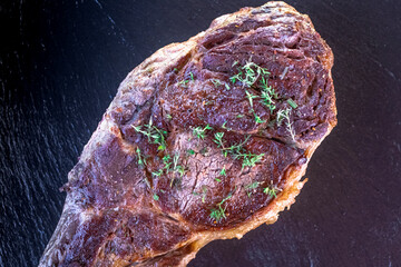 Côte de bœuf grillé au barbecue ou à la plancha cuit à point avec du thym frais.