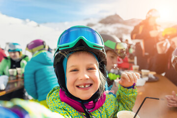 Cute adorable happy funny caucasian little toddler boy enjoy having family fun and making selfie with phone at alpine mountain european ski resort on sunny winter day. Playful smiling child portrait
