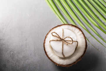 Fototapeta na wymiar Handmade coconut oil soap white color with palm leaf on grey concrete background.