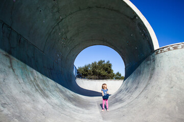 kleines Kind in einem Skatepark Tunnel