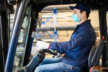 A handsome construction worker driving a forklift in an industrial plant © Minerva Studio