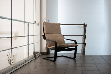 Modern wooden comfy armchair sitting in an indoor balcony floor