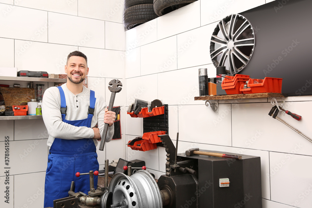 Wall mural mechanic near car disk lathe machine at tire service