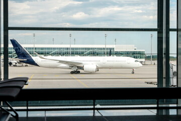 Generic regional flight airplane as seen from inside generic international airport terminal taxi towards runway