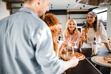 Happy two adult women eating pizza at home
