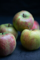 five red and green apples black background close up