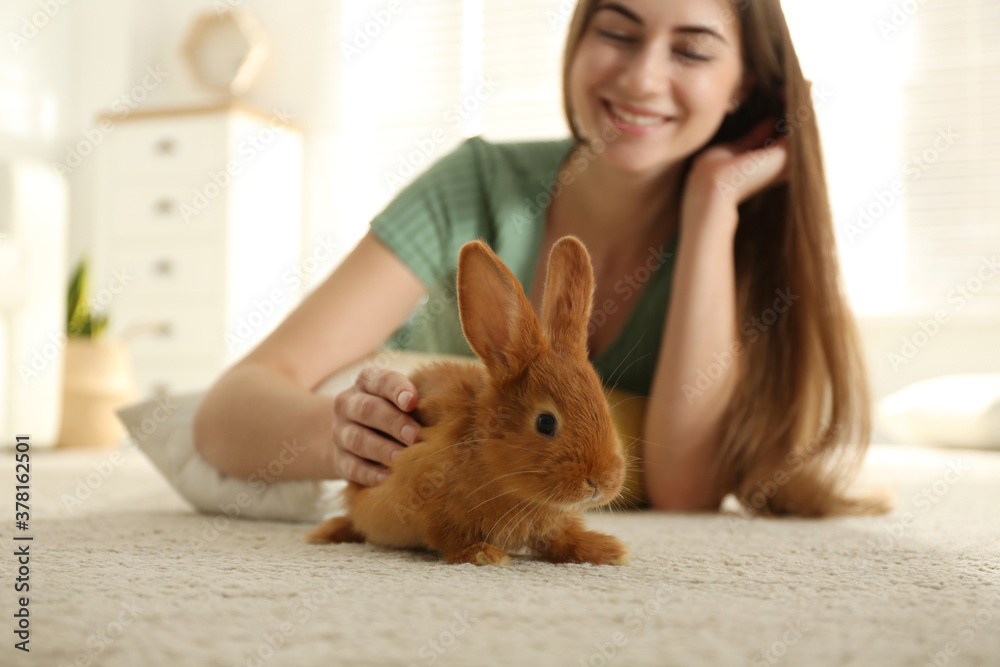 Canvas Prints Young woman with adorable rabbit on floor indoors. Lovely pet