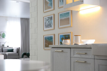 Stylish kitchen interior with beautiful artworks on wall