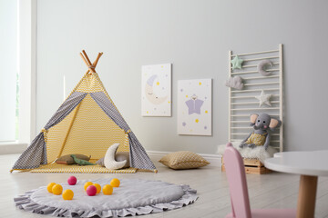 Stylish child's room interior with adorable paintings and play tent © New Africa