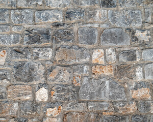 grey and brown stone wall closeup, rough pattern background