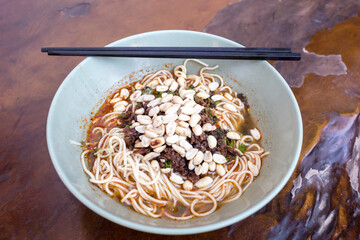 Sichuan style noodles like spicy noodle with chicken gizzard, minced, vegetables and peanut, Chinese cuisine