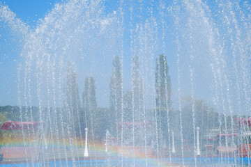 artesian fountain on blue sky with rainbow