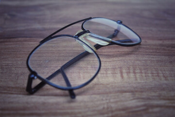 An old eye glass with some scratches on the wooden table.