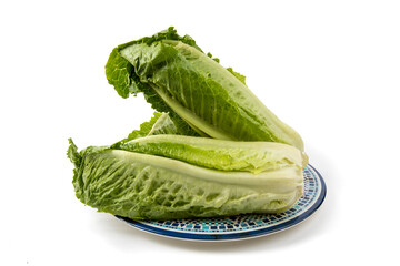 three Romaine lettuce hearts on a blue plate isolated on white