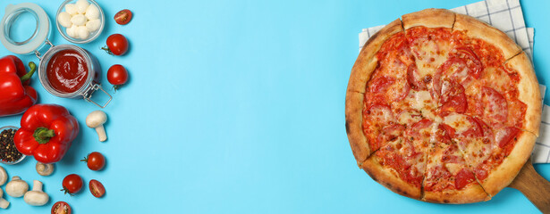 Tasty pizza and ingredients on blue background