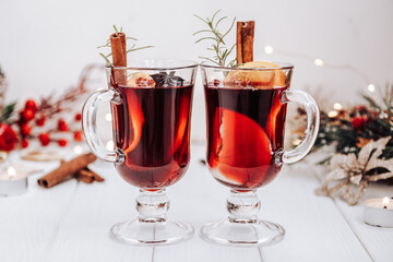 Two glasses of mulled wine on the table surrounded by New Year's lights. Festive mood