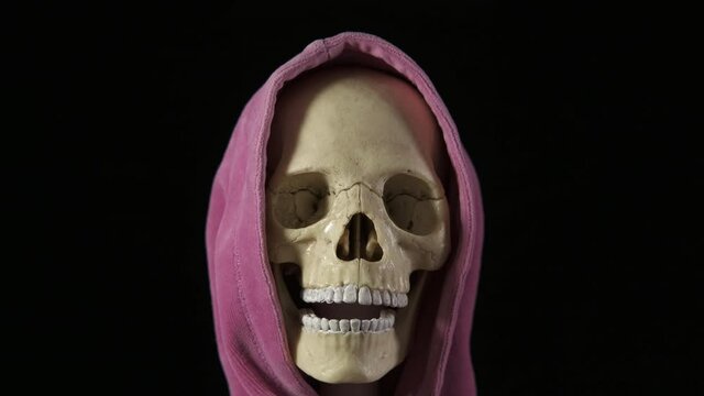 Skull in the shadows. A view of a skull in a hood on the black background.