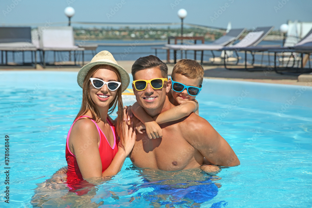 Poster Happy family in swimming pool on sunny day