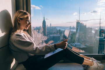 Happy female blogger watching positive video vlog on streams website connecting to 4g internet on...