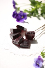 Handmade marmalade of dark color from grapes, on a white background.
