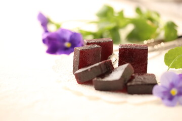 Handmade marmalade of dark color from grapes, on a white background.
