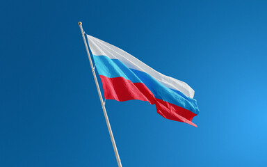 Isolated Russia flag waving in the wind against blue sky background. Russian national flag close up