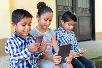 three children looking at their tablets